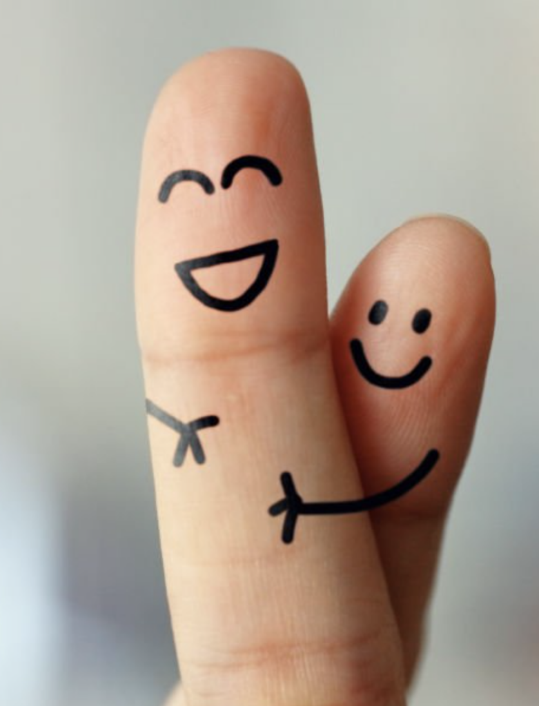 Two fingers with drawn smiling faces hugging.